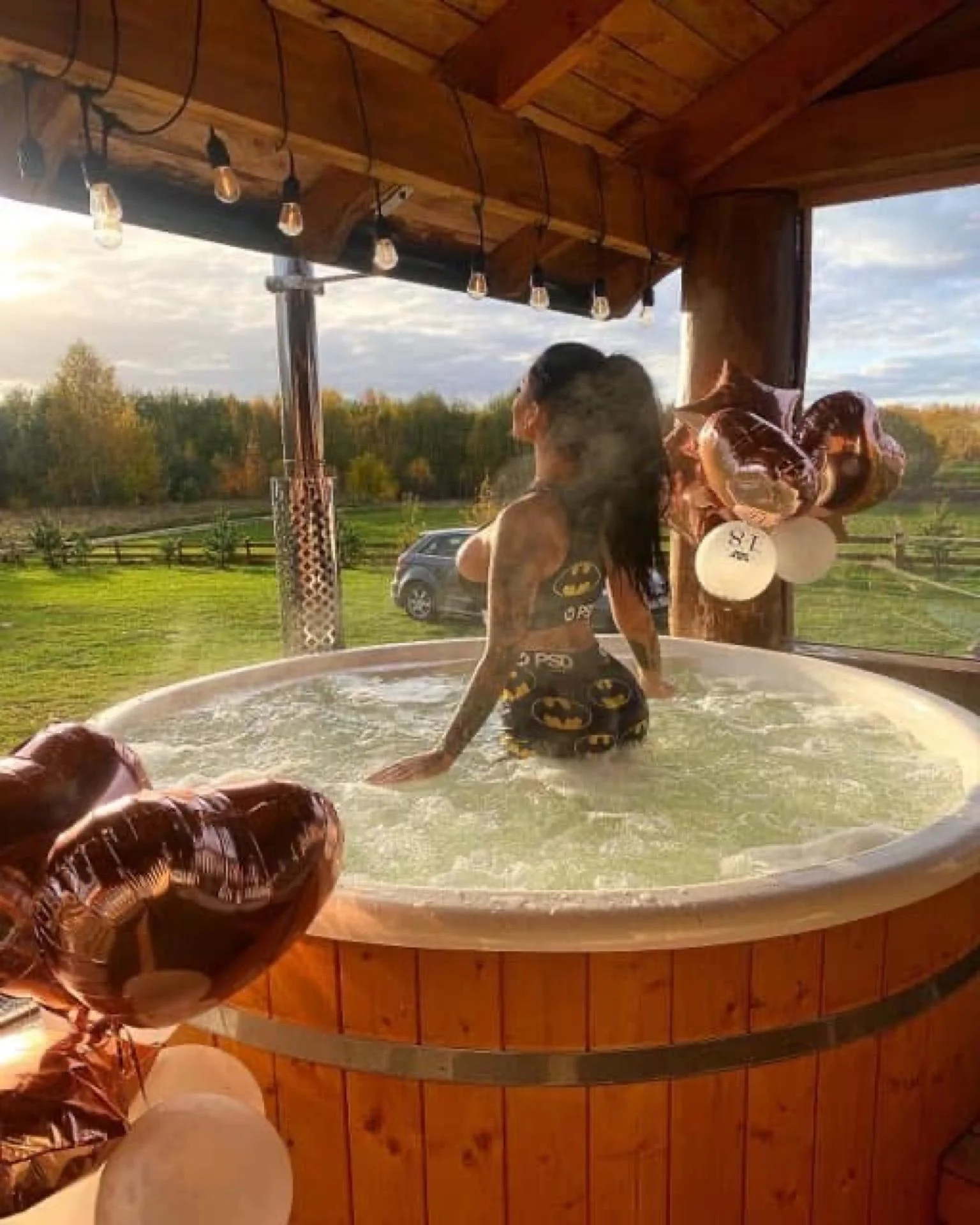 Jacuzzi pod gołym niebem zimą, lampki i widok na jezioro